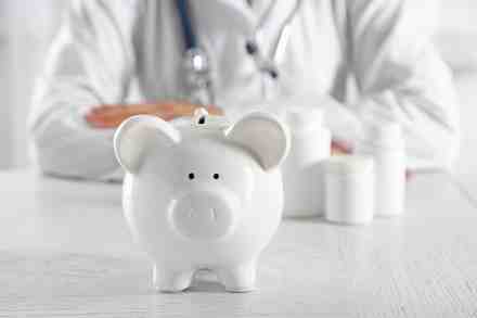 Arzt sitz hinter Sparschwein