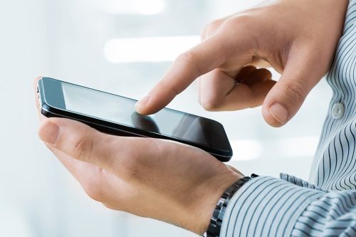 Person tippt auf Mobiltelefon